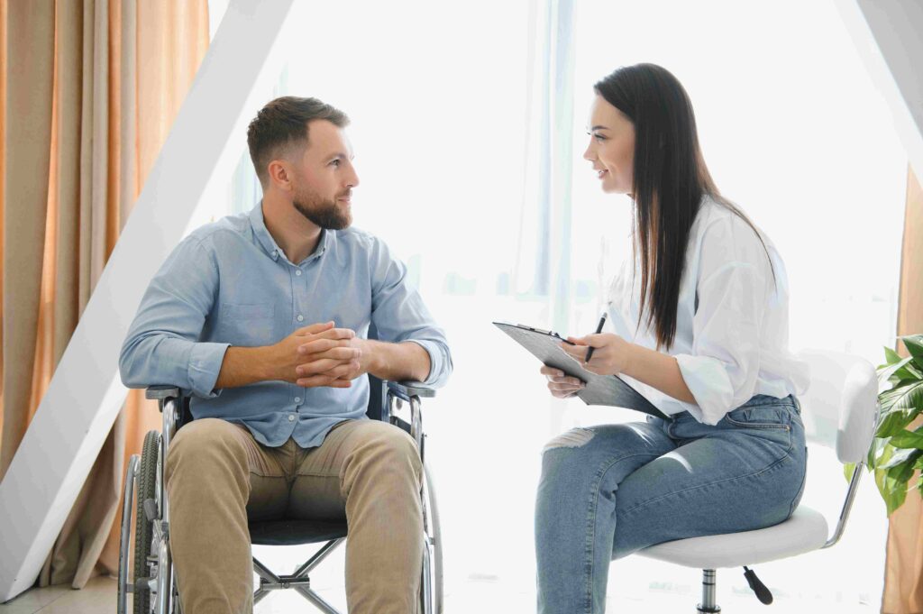 Young bearded man on wheelchair during home psychotherapy.