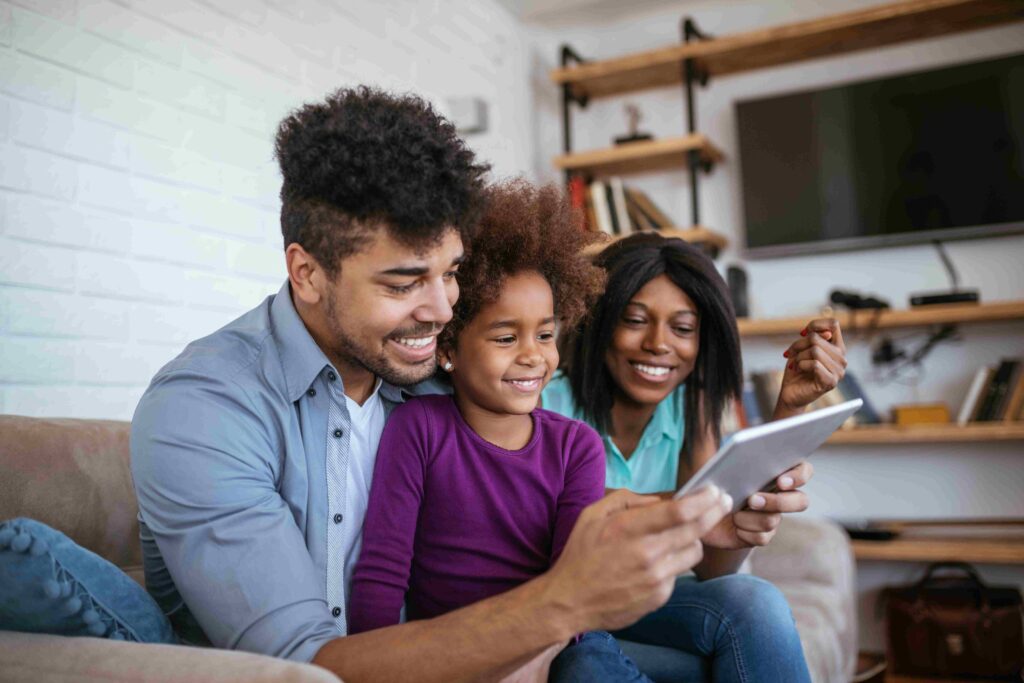 Young family with child having fun using modern technology
